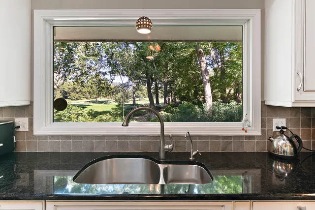 a bathroom with a granite countertop sink a toilet and a mirror
