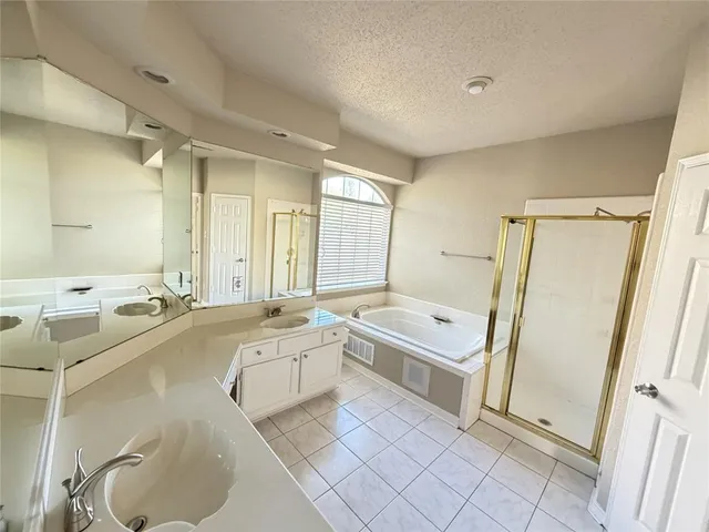 a large bathroom with a tub a sink and a mirror