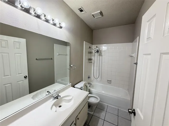 a bathroom with a tub sink toilet and a mirror