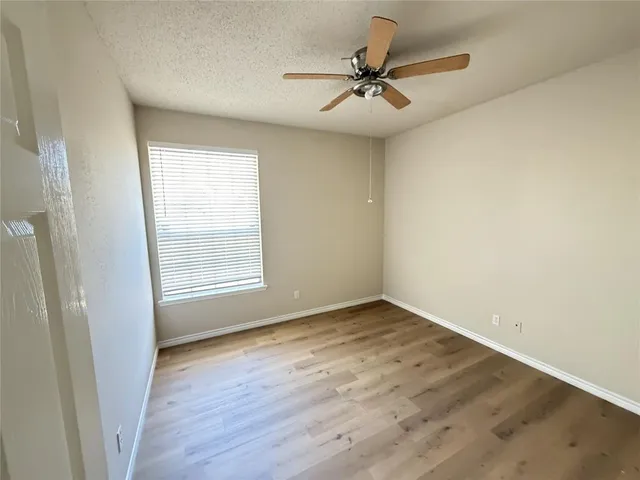 a view of a room with wooden floor and a window