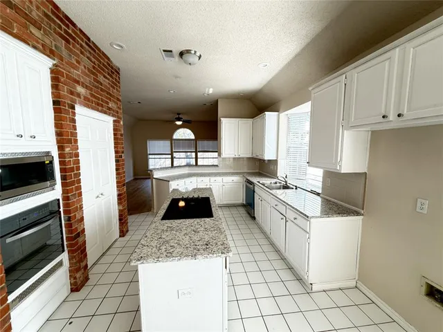 a kitchen with a sink a counter top space cabinets and stainless steel appliances