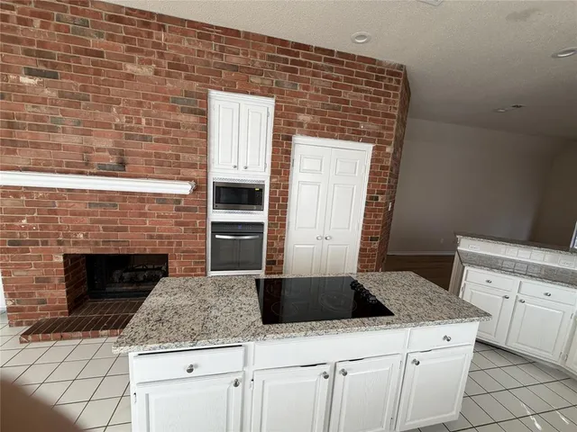 a kitchen with granite countertop a stove sink and cabinets