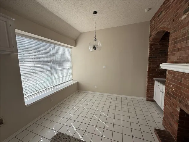 a view of an empty room with a fireplace and a window