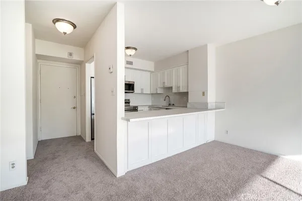 a kitchen with white cabinets and refrigerator