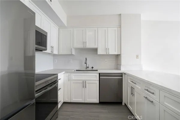 a kitchen with white cabinets stainless steel appliances and sink