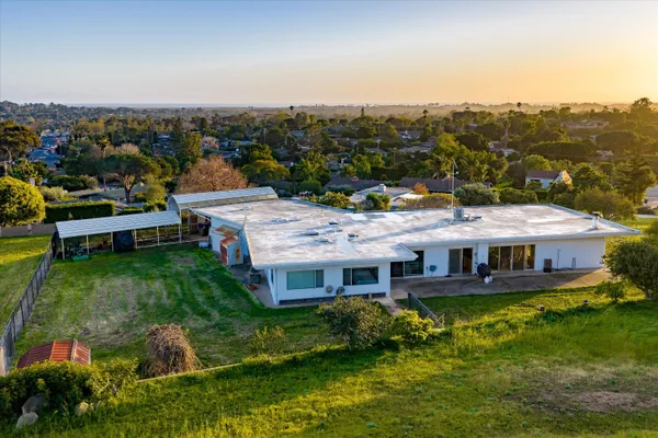 a aerial view of a house with a garden and lake view