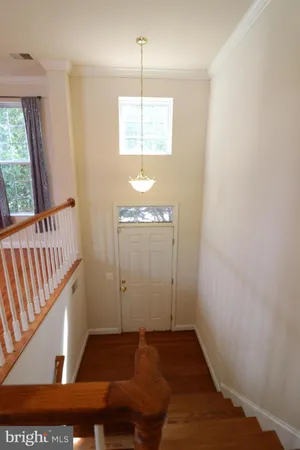 a view of a hallway with wooden floor and a window