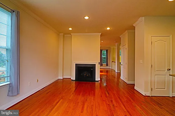 a view of a hallway with wooden floor and a fireplace