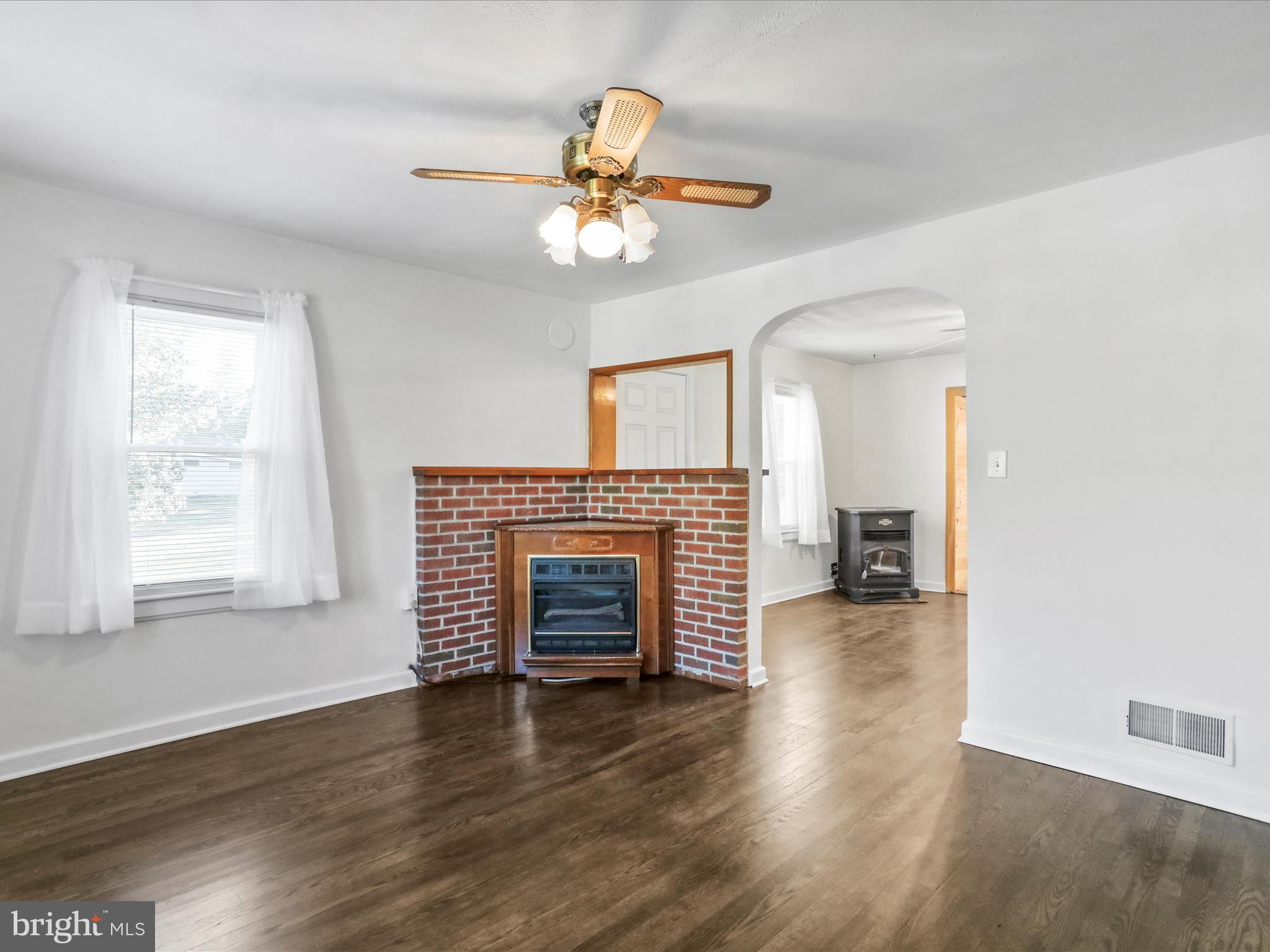 25411 Cascade Road Cascade, MD 21719 - Photo 7 of 53 an empty room with wooden floor fireplace and windows