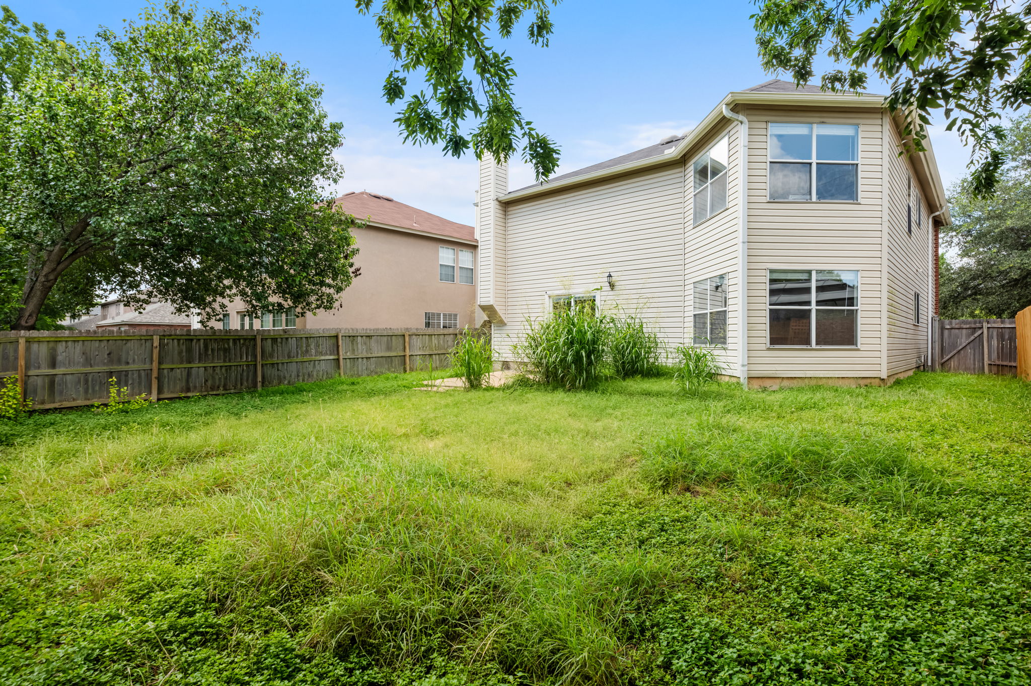 1408 Water Spaniel Way Round Rock, TX 78664 - Photo 33 of 37 A spacious, unfurnished backyard with a two-story home, perfect for outdoor activities.