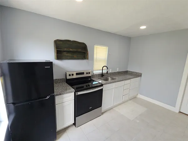 a kitchen with stainless steel appliances granite countertop a refrigerator and a stove