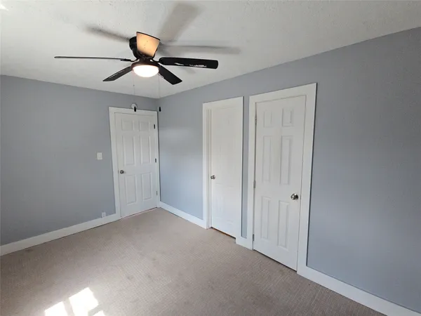 a view of an empty room and a ceiling fan