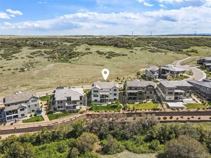 an aerial view of residential houses with outdoor space and ocean view