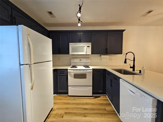 a kitchen with a refrigerator sink and cabinets