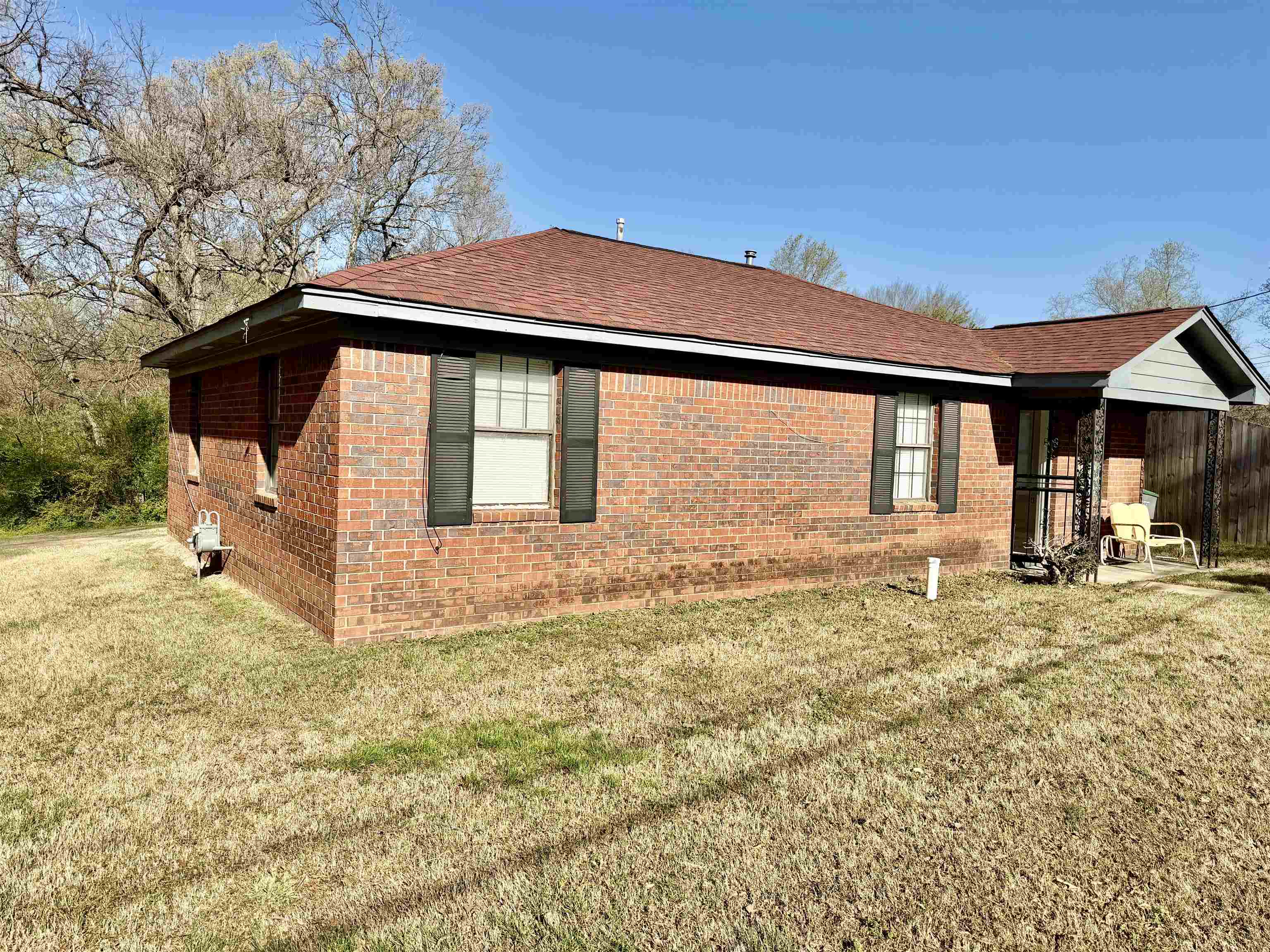 2215 Henrietta Road Memphis, TN 38134 - Photo 1 of 10 View of home's exterior with brick siding, a shingled roof, and a lawn