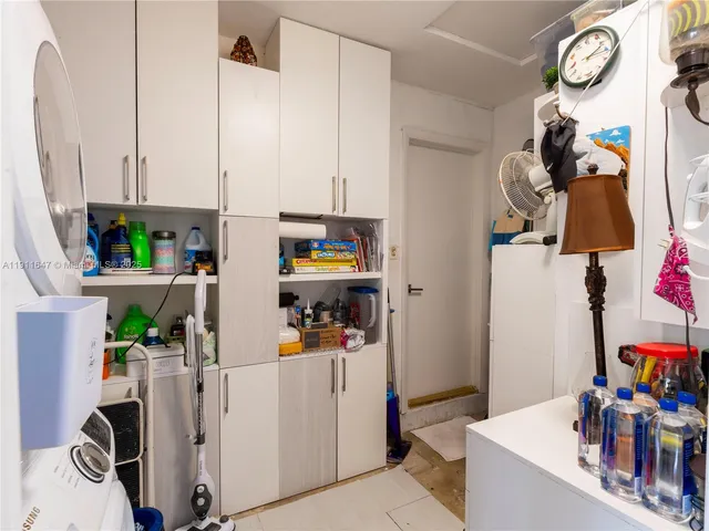 a kitchen with stainless steel appliances a white table chairs and a potted plant