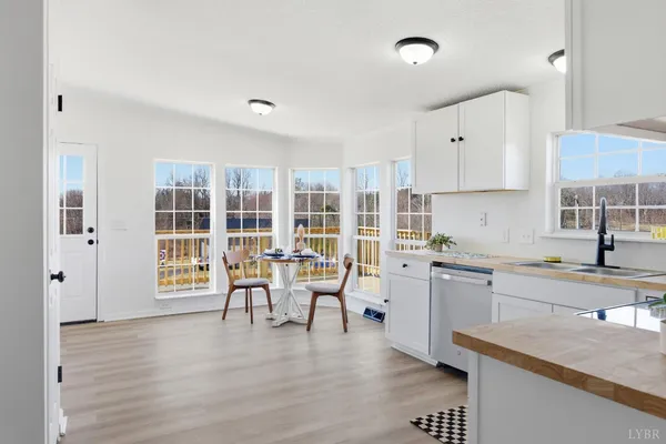 a kitchen with granite countertop a stove a sink a dining table and chairs