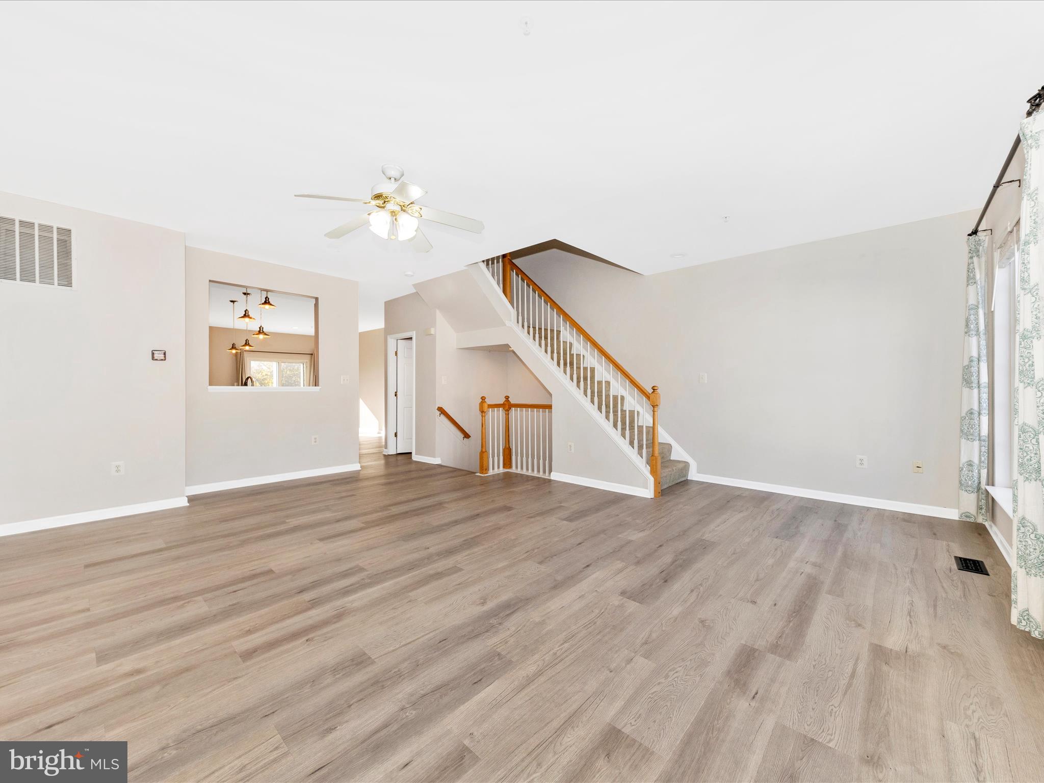 2103 Paxton Terrace Frederick, MD 21702 - Photo 13 of 51 a view of an empty room with wooden floor and a ceiling fan