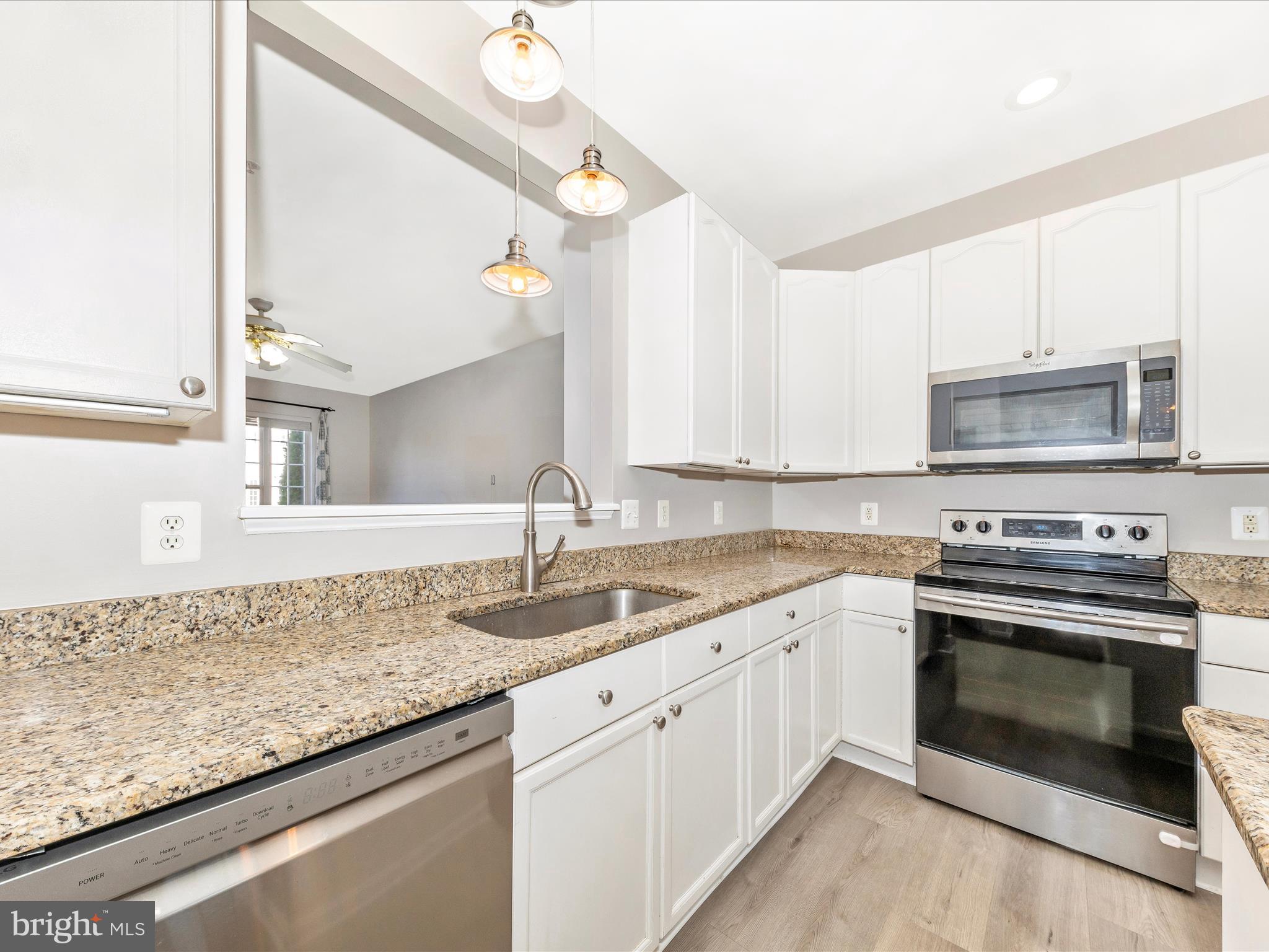 2103 Paxton Terrace Frederick, MD 21702 - Photo 16 of 51 a kitchen with granite countertop a sink stainless steel appliances and white cabinets