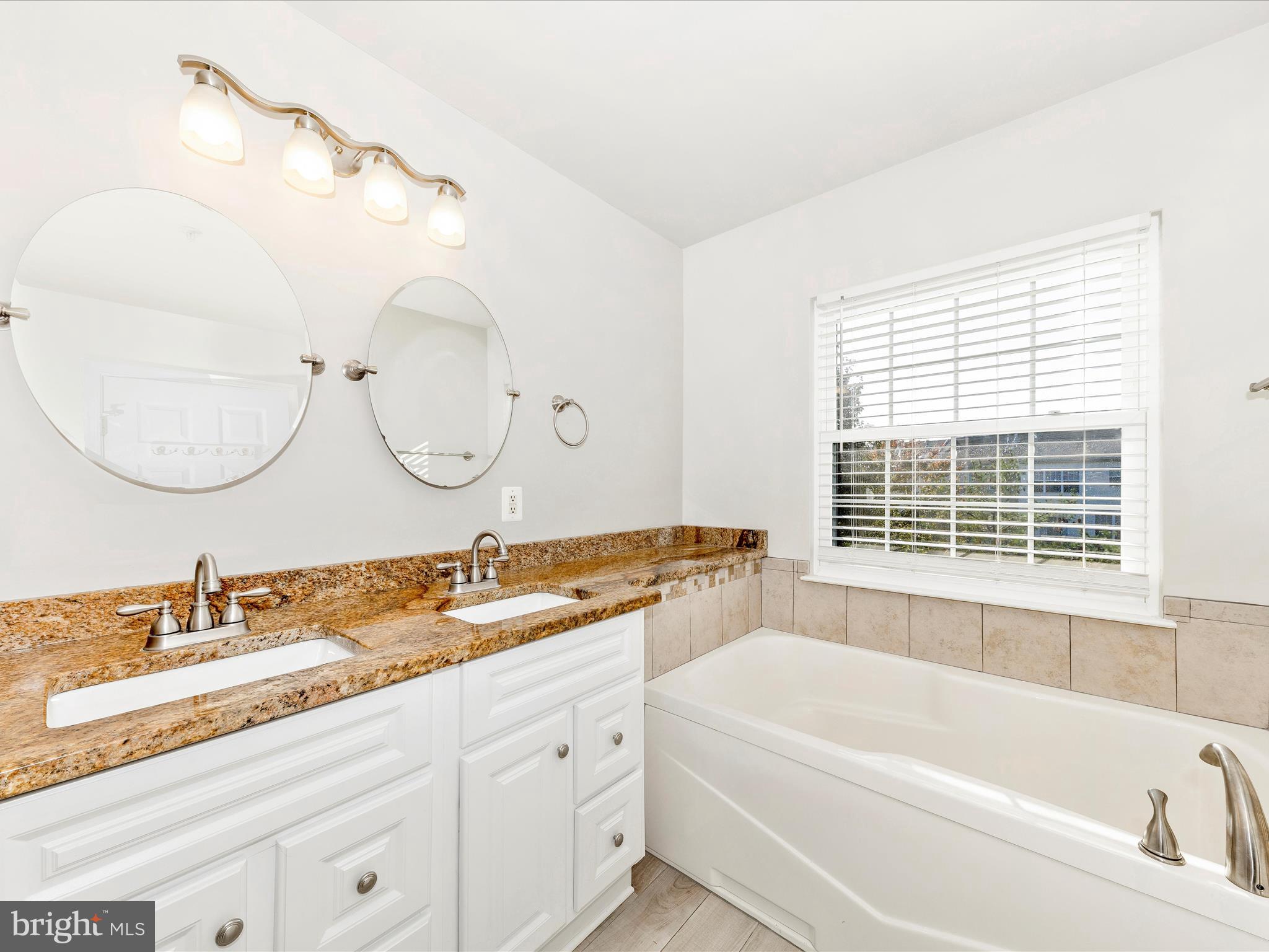 2103 Paxton Terrace Frederick, MD 21702 - Photo 28 of 51 a bathroom with a tub a double vanity sink and mirror