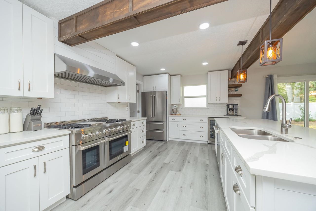 110 Queen Road St. Augustine, FL 32086 - Photo 14 of 37 a kitchen with stainless steel appliances granite countertop a sink stove and refrigerator