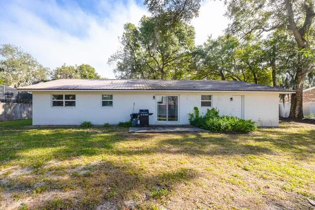 a view of a house with a yard and a large tree