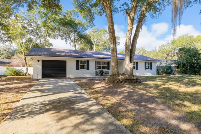 a view of a house with a tree in front of it
