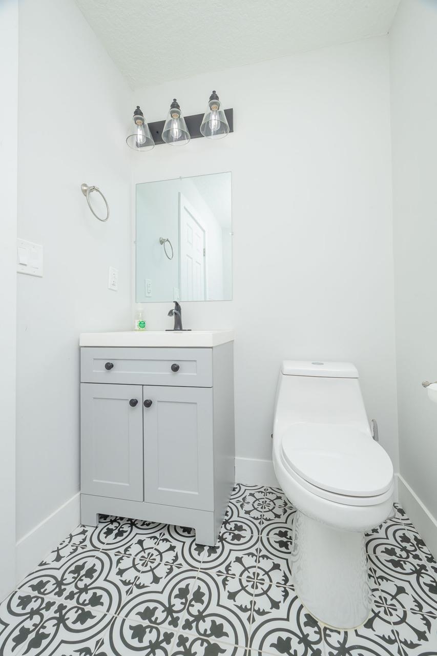 110 Queen Road St. Augustine, FL 32086 - Photo 34 of 37 a bathroom with a sink a toilet and a mirror