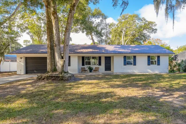 a view of a house with a swimming pool and a large tree