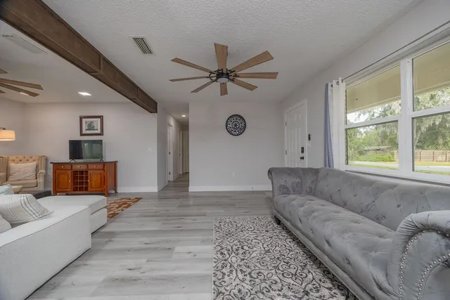 a living room with furniture and a wooden floor