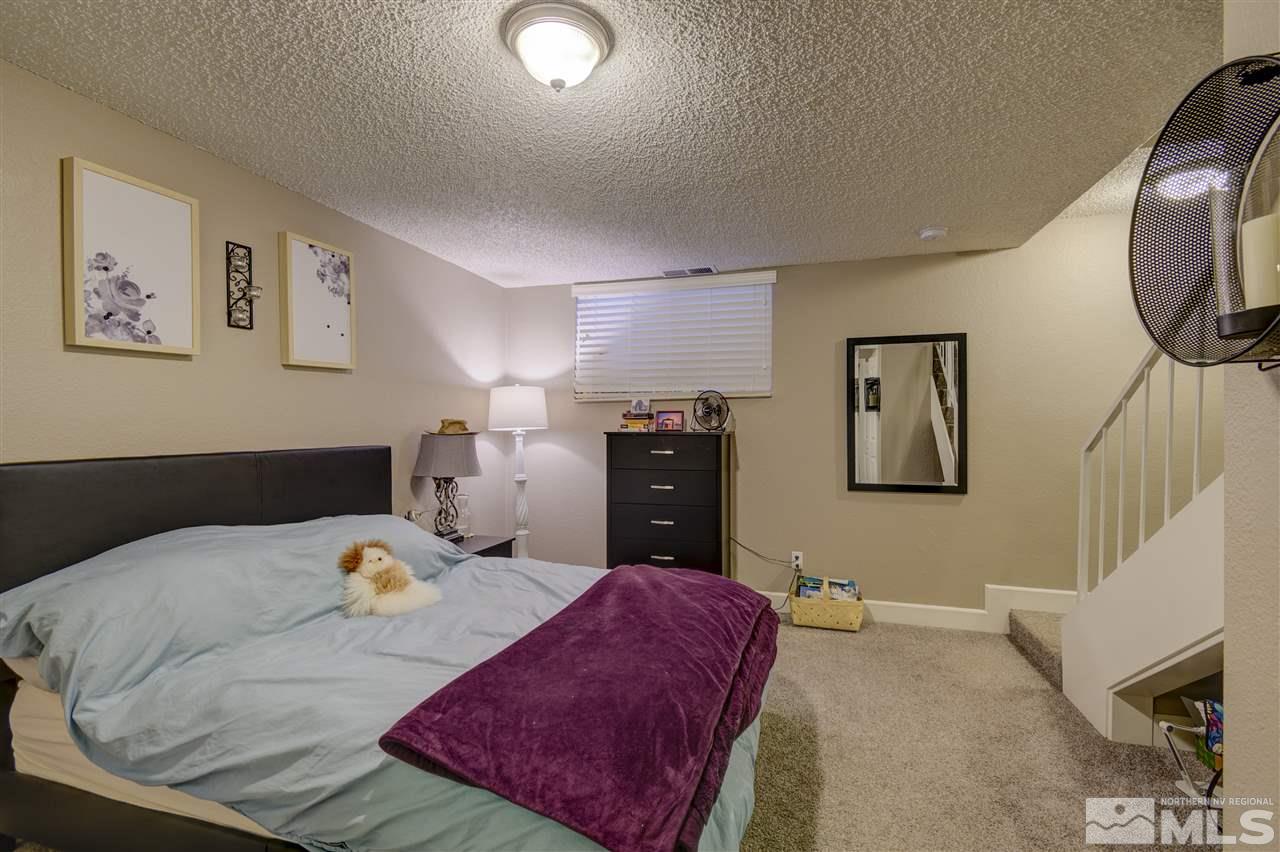 1408 East 9th Street Reno, NV 89512 - Photo 18 of 25 a bedroom with a large bed and a chandelier
