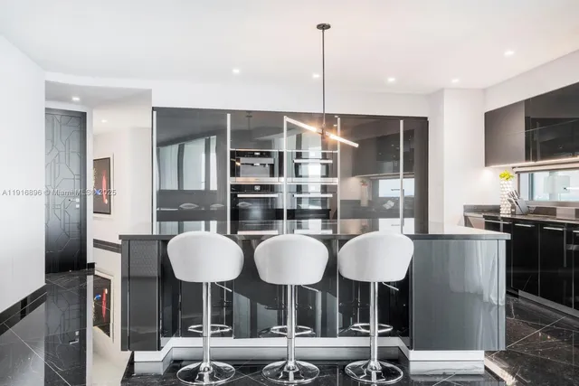 a kitchen with stainless steel appliances granite countertop a table and chairs