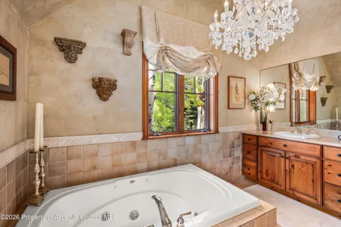 a bathroom with a tub sink and a large mirror