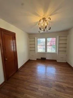 an empty room with wooden floor and window