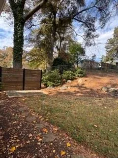 a view of a yard with wooden fence