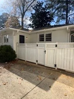 a view of a white house with a large space in front of it