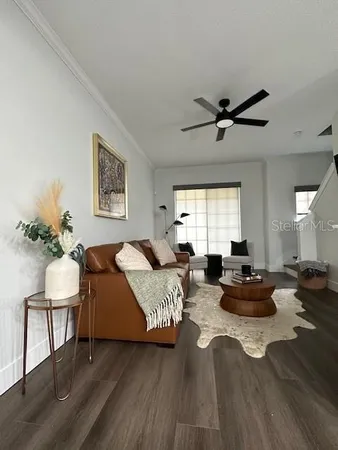 a living room with furniture wooden floor and a window