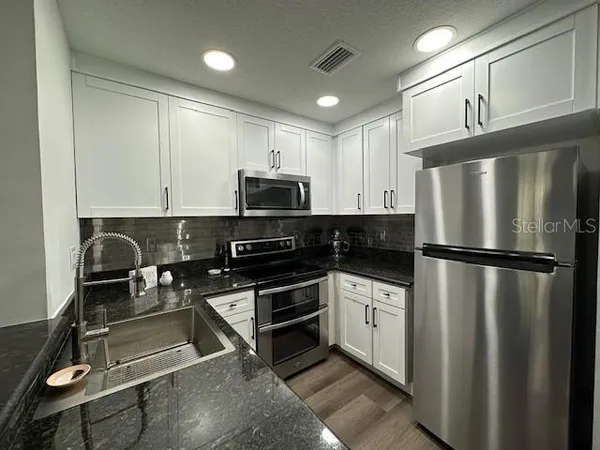 a kitchen with a refrigerator a microwave and sink