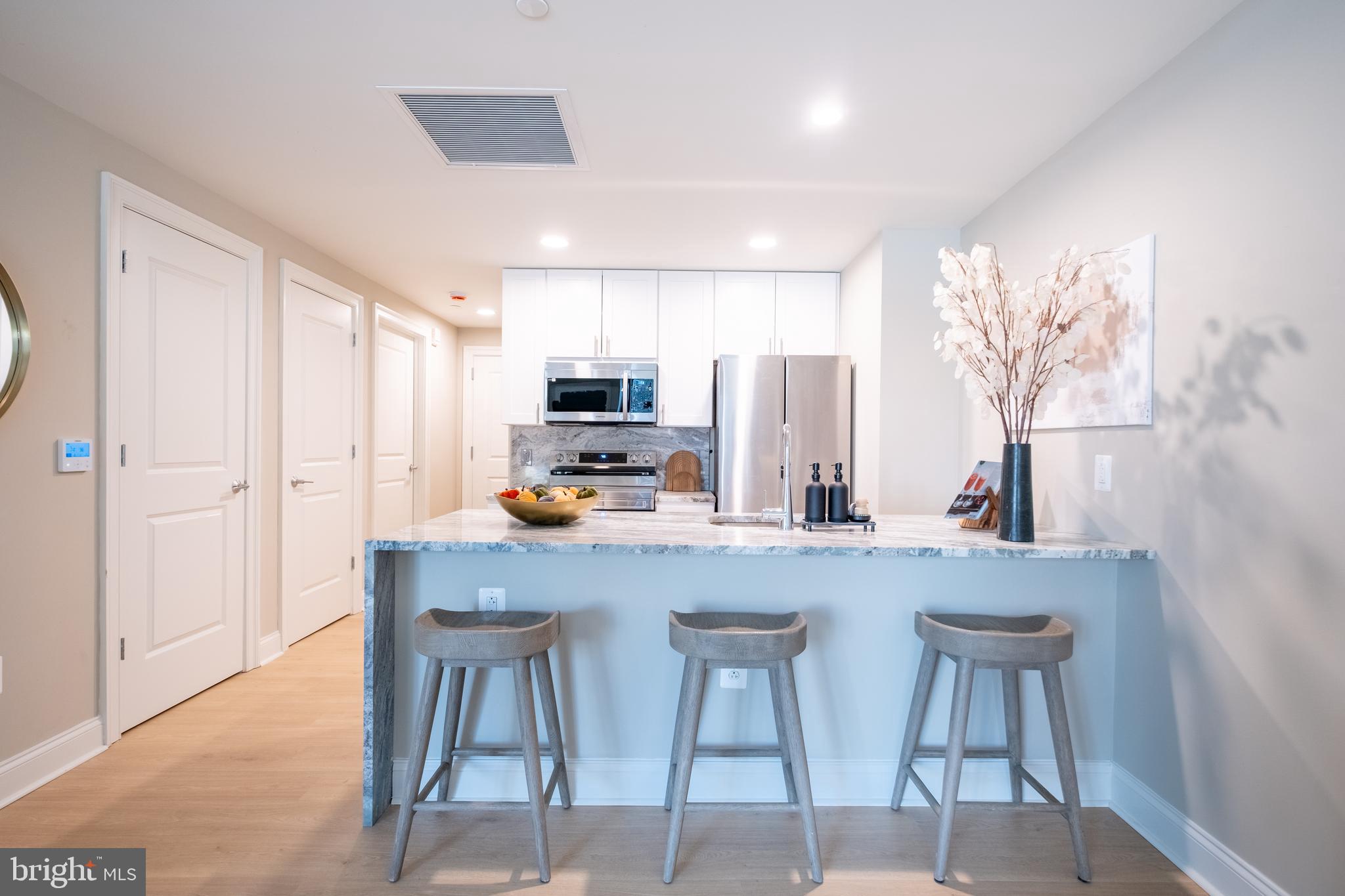 2301-61 John F Kennedy Boulevard, Unit 208 Philadelphia, PA 19103 - Photo 3 of 36 a kitchen with stainless steel appliances a table and chairs in it