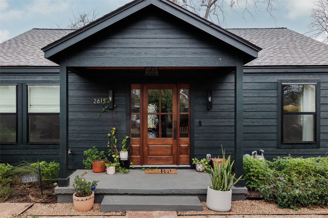 a front view of a house with potted plants