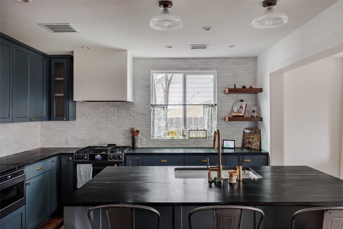 2613 East 2nd Street Austin, TX 78702 - Photo 11 of 30 a kitchen with a table chairs and cabinets