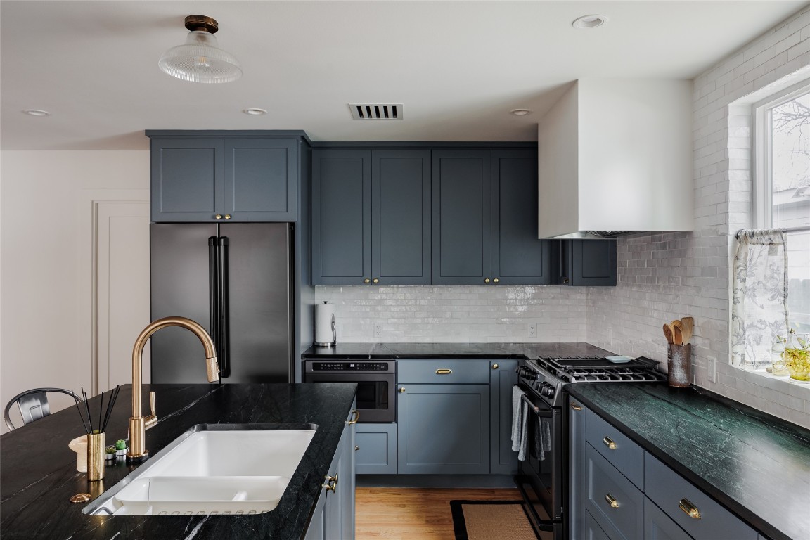 2613 East 2nd Street Austin, TX 78702 - Photo 12 of 30 a kitchen with a sink a stove and cabinets