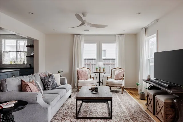 a living room with furniture a flat screen tv and a large window