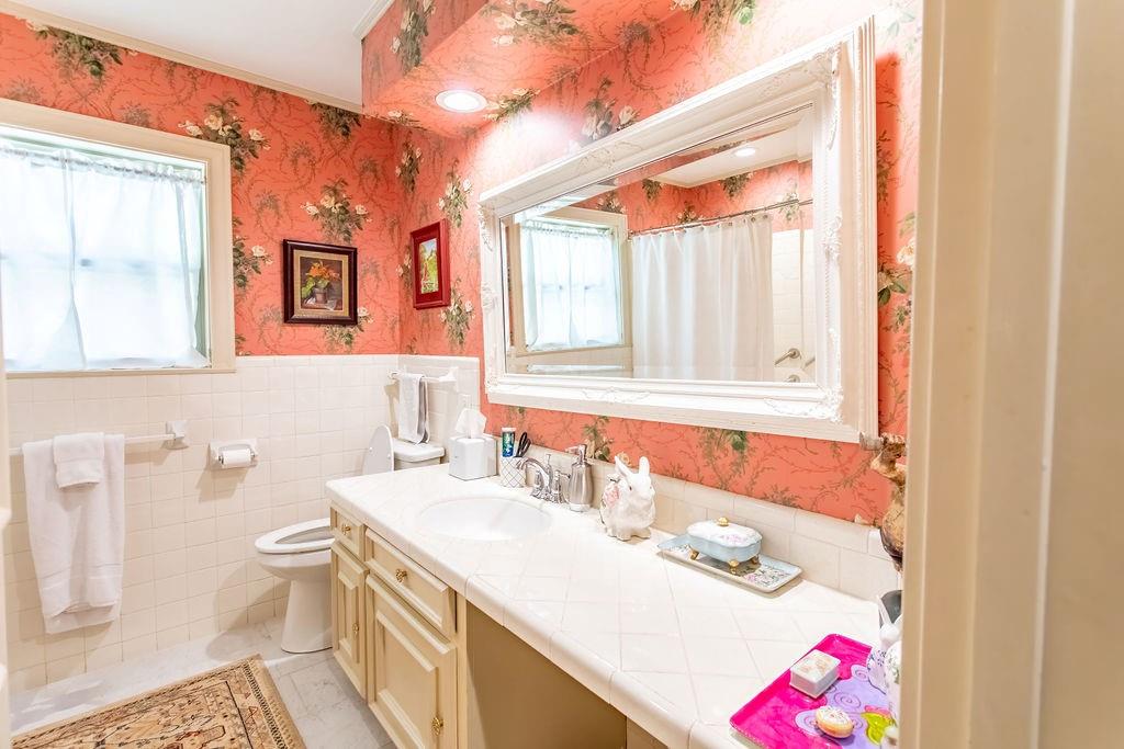 149 Russ Street Albany, TX 76430 - Photo 17 of 25 a bathroom with a sink vanity mirror and toilet