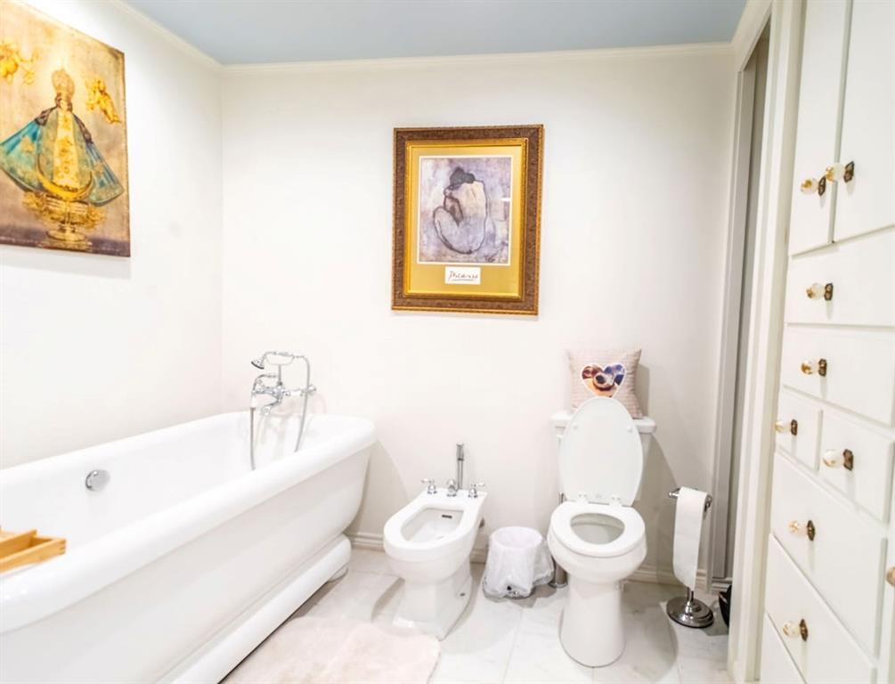 149 Russ Street Albany, TX 76430 - Photo 20 of 25 a white toilet sitting next to a bathroom sink and tub