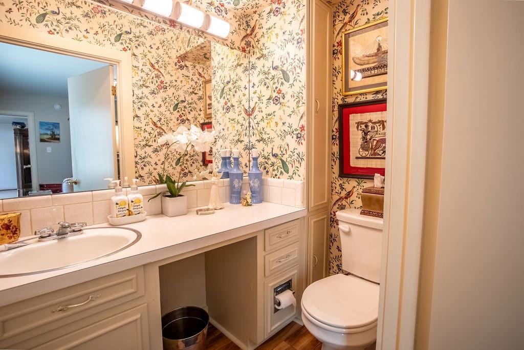 149 Russ Street Albany, TX 76430 - Photo 8 of 25 a bathroom with a granite countertop toilet sink and mirror