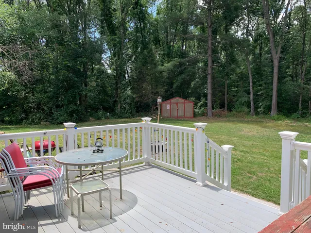 an empty room with wooden floor chandelier fan and windows