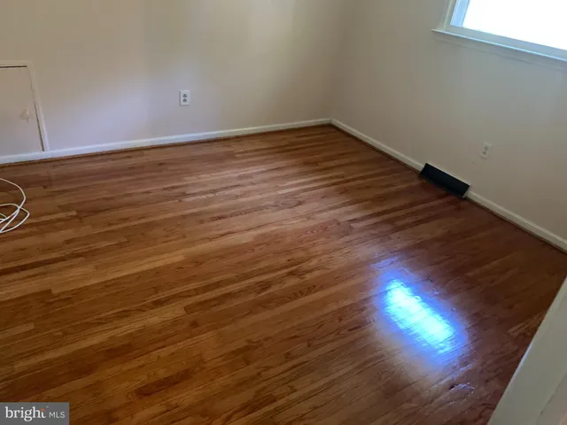 a view of room with wooden floor and windows