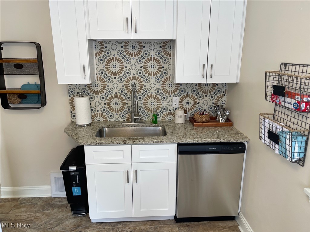 1539 Winchester Road Lyndhurst, OH 44124 - Photo 7 of 21 Kitchen featuring dishwasher, decorative backsplash, sink, white cabinets, and light stone counters