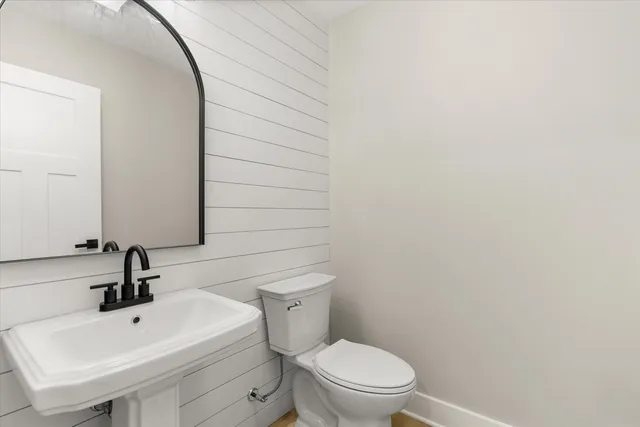 a bathroom with a toilet a sink and mirror
